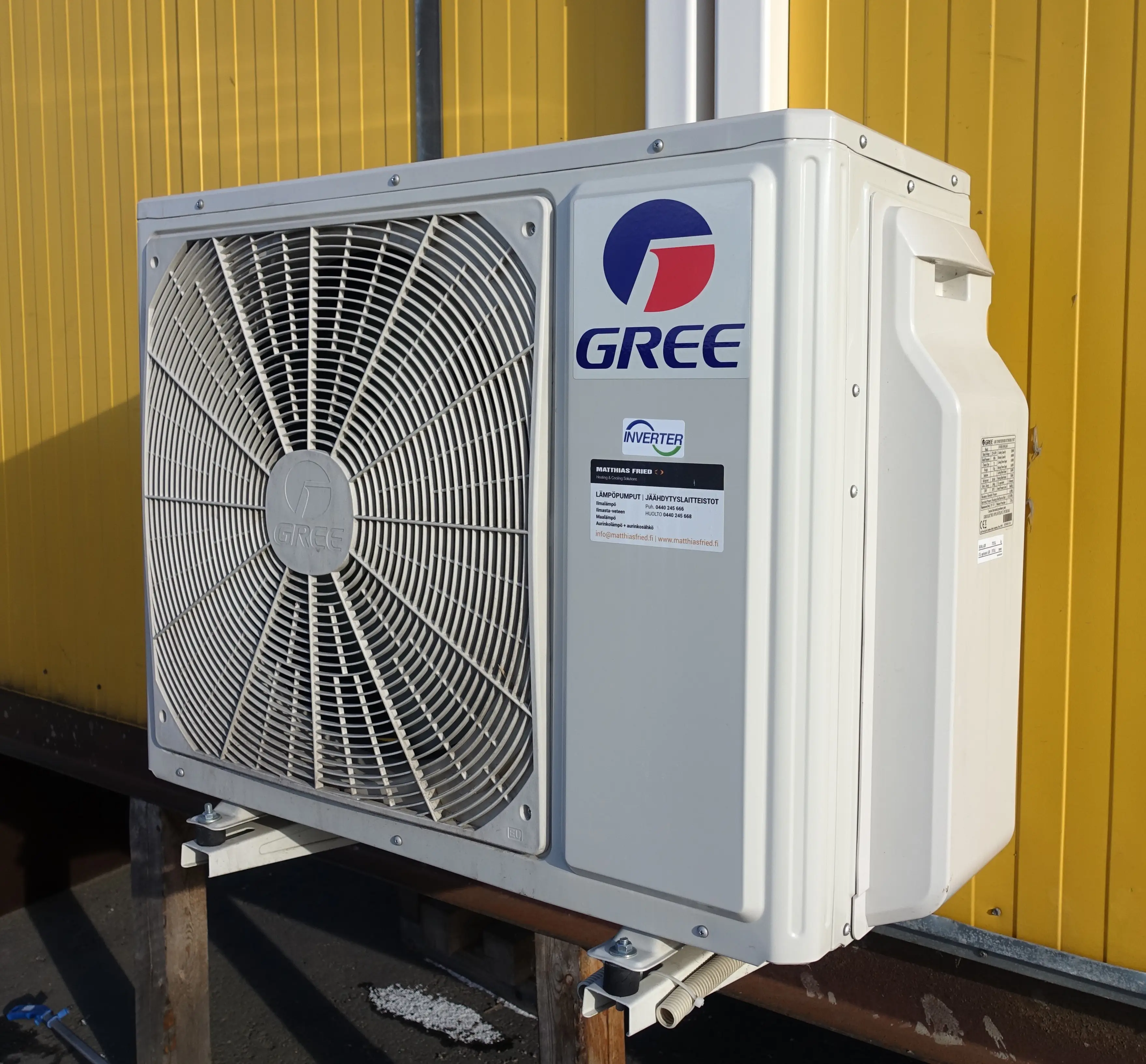 Cold climate heat pump outdoor unit running in snowy winter conditions